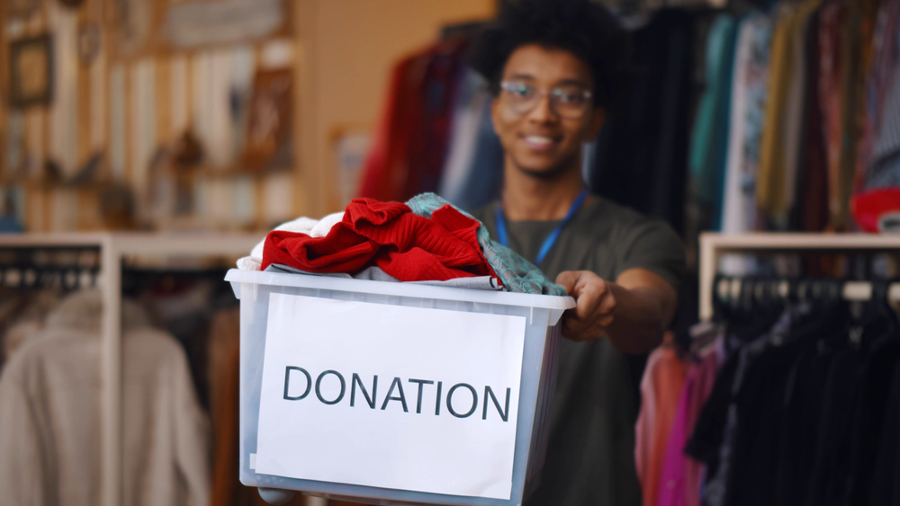 African,American,Guy,Holding,Donation,Box,And,Looking,At,Camera